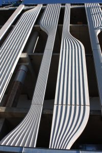 Side view of the precast concrete cladding. A flat geometric shape is cut through by vertical geometric curves that form more organic shapes.