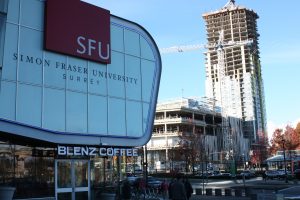 A more distant side view of the precast concrete cladding. Another university building can be seen in the foreground with a Blenz coffee integrated into it. It is a clear day.