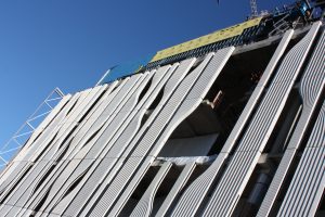 Side view of the precast concrete cladding. A flat geometric shape is cut through by vertical geometric curves that form more organic shapes.
